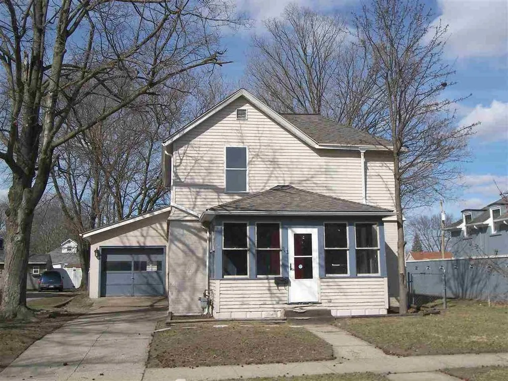 Front of 1123 East Main Street, a two-story house with an enclosed front porch and an attached garage
