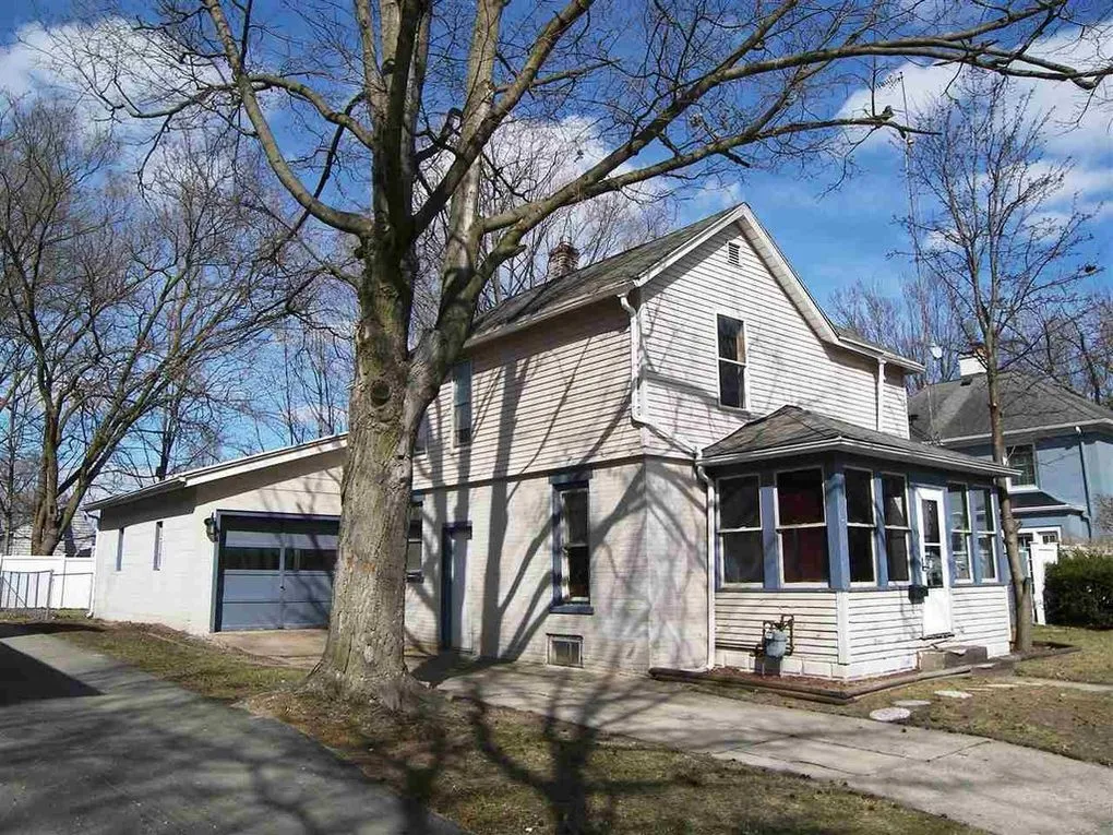 Side view of the house showing the porch, the attached garage and the driveway