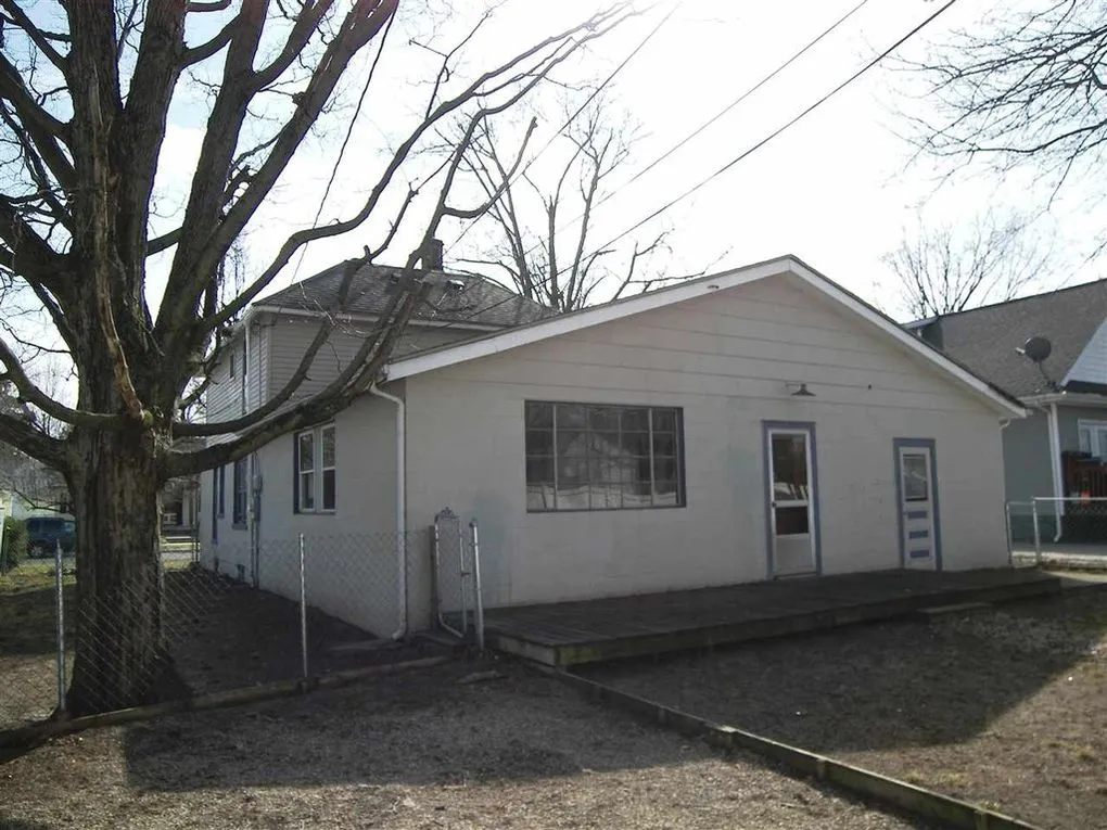 Back of the house, a single-story rear section with a wooden deck and two doors